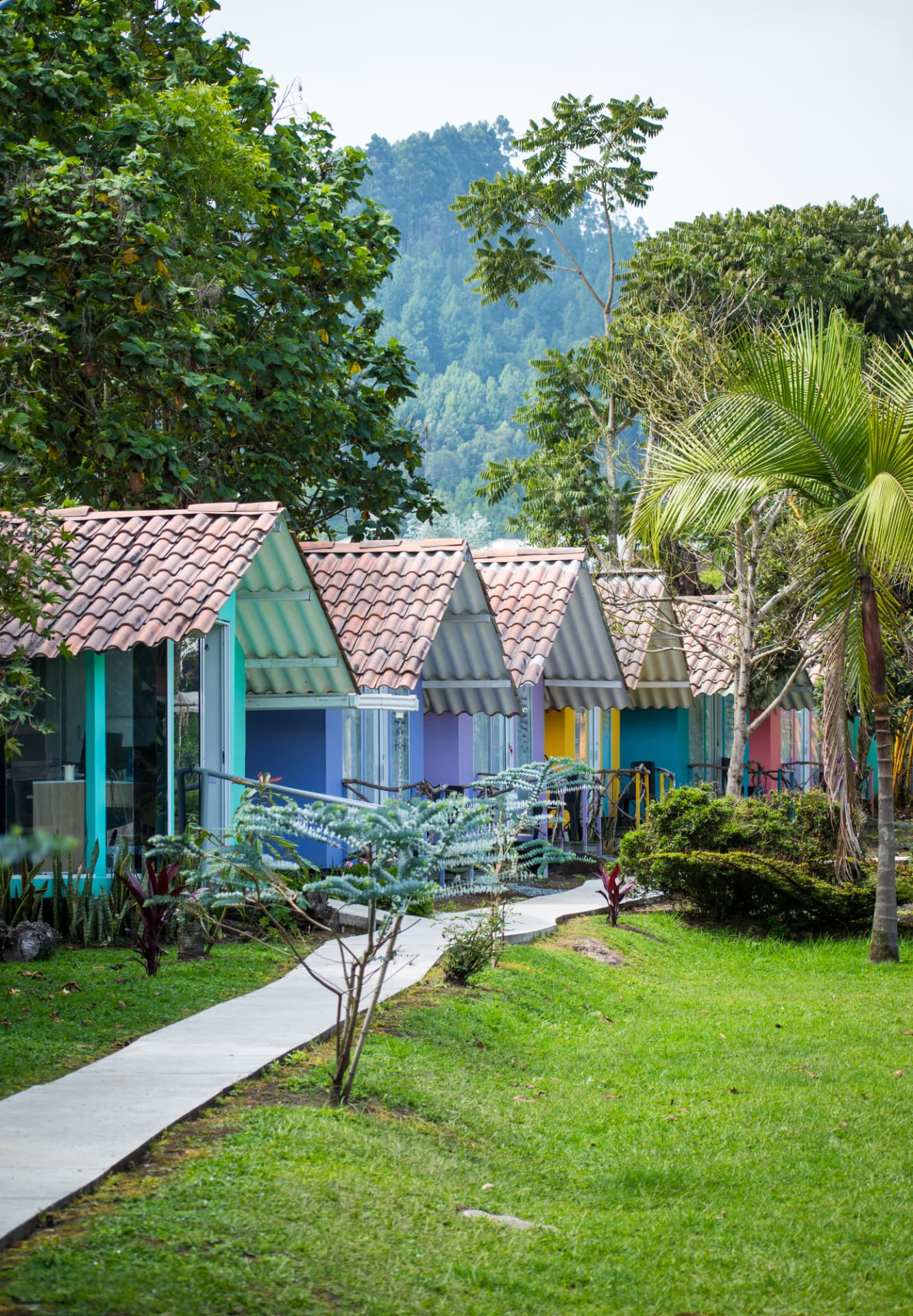 Cabañas coloridas rodeadas por jardines y montañas
